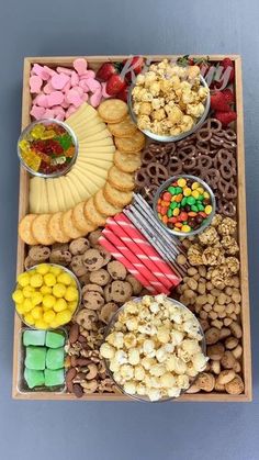 a wooden tray filled with lots of different snacks and desserts on top of it