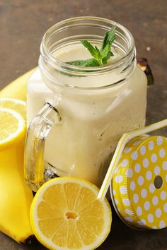 a mason jar filled with lemonade next to sliced lemons