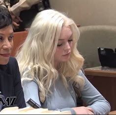 two people sitting at a table with food