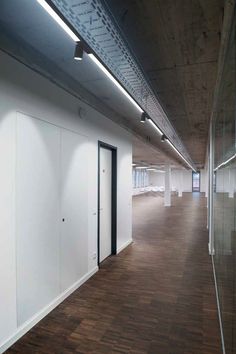 an empty room with white walls and wooden floors is seen in this image from the hallway