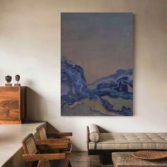 an abstract painting hangs on the wall in a living room