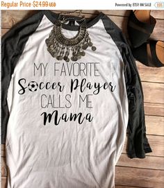 a shirt that says soccer mama with a necklace on the front and an earring hanging from it