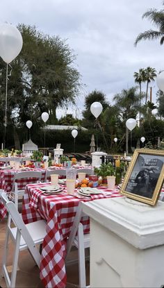 tables set up with red and white checkered tablecloths for an outdoor party