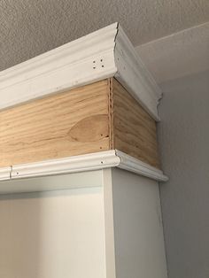 a white shelf with some wood on it and a light fixture in the corner behind it