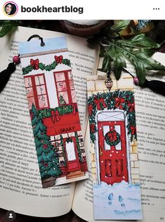 two christmas bookmarks sitting on top of an open book