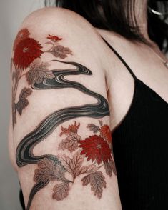 a woman's arm with a snake and flowers on it