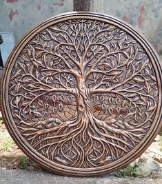 an intricately carved wooden tree of life plaque