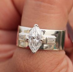 a woman's engagement ring with a pear shaped diamond in the center and baguettes on each side