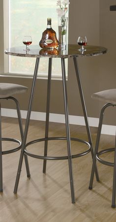 a glass table with two stools next to it and a bottle of wine on top