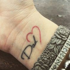 a person with a tattoo on their wrist and the word love is written in red ink