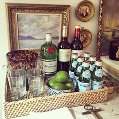 there are many bottles and glasses in the basket on the counter next to each other