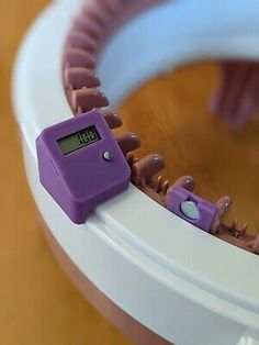 a purple clock sitting on top of a white table