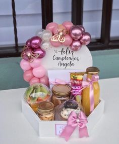 a box filled with lots of food on top of a white table next to a window