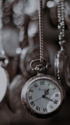 an old pocket watch is hanging from chains