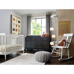 a baby's room with a rocking chair, crib and dresser