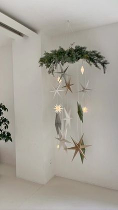 a white room with a christmas tree hanging from it's ceiling and decorations on the wall