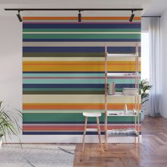 a colorful striped wall mural in a living room with a ladder and potted plant