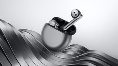 an airpods is sitting on top of a metal object in the shape of waves