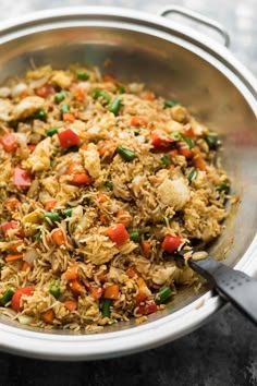 a pan filled with rice and vegetables on top of a table