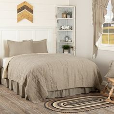 a bed room with a neatly made bed and wooden floors