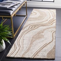 a large rug in the middle of a room with a bench and window behind it