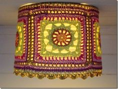 a crocheted lamp shade hanging from the ceiling