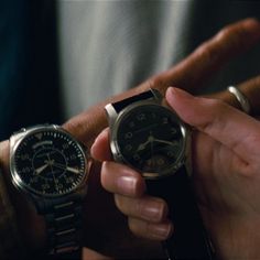 two people holding watches in their hands