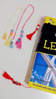 a book sitting on top of a table next to some beads and tassels