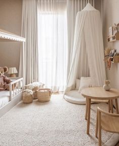 a child's bedroom with a canopy bed and white curtains