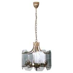 an antique brass chandelier with clear glass panels and metal chains hanging from the ceiling