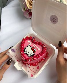 a hello kitty heart shaped cake in a plastic container