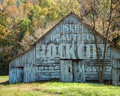 an old wooden barn with writing on it