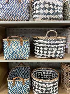 baskets are lined up on the shelves in a storage area at a store, and one is blue and white