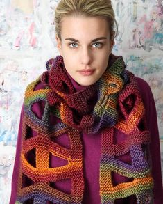 a woman wearing a purple sweater and colorful knitted scarf with an interlocked design