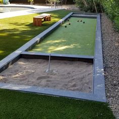 a miniature golf course in the backyard with sand and artificial grass on the ground next to it