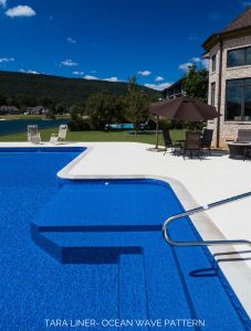 an empty swimming pool in front of a large house