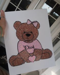 a hand holding up a card with a teddy bear on it's chest that says, do