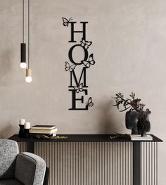 a black metal sign that says home on the wall next to a chair and table