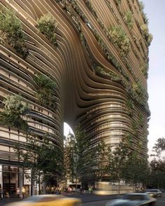 an architecturally designed building with trees growing on it's side and cars passing by