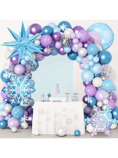 a balloon arch decorated with blue, purple and silver balloons for a winter wonderland party