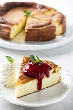 a piece of cheesecake on a plate with whipped cream and raspberry sauce