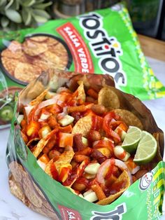 a bag of nachos sitting on top of a table next to some chips