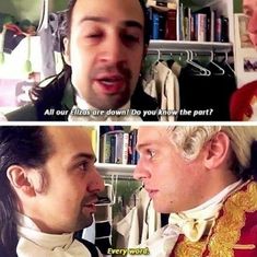 two men are talking to each other in front of a bookshelf and one has his mouth open