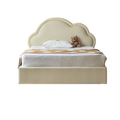 a teddy bear sitting on top of a bed with white sheets and headboard in the shape of a cloud