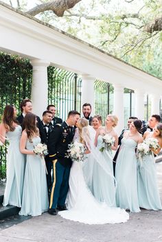 a bride and groom with their bridal party in front of an iron gate at the white house