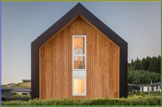 a wooden building with two windows in front of it