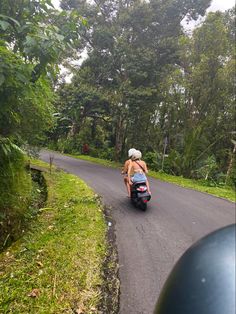 a person riding a motor scooter down a road