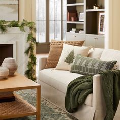 a living room filled with furniture and a fire place in front of a christmas tree