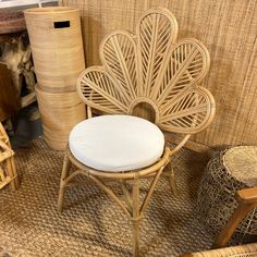 a wicker chair with a white cushion in front of other wicker furniture and baskets