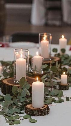 a table topped with candles and greenery